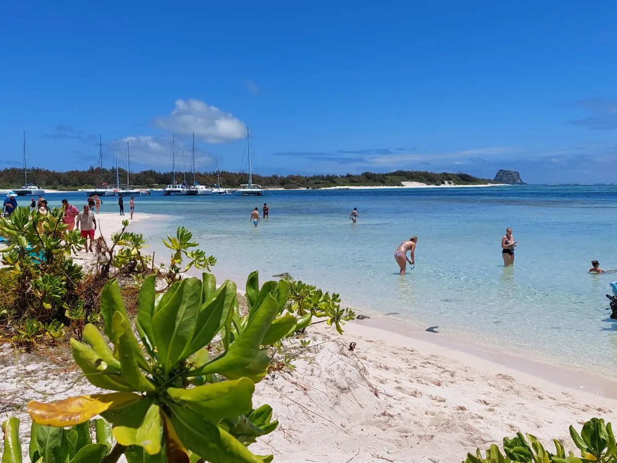People enjoying the sea at Gabriel Island beach in Mauritius on a sunny day