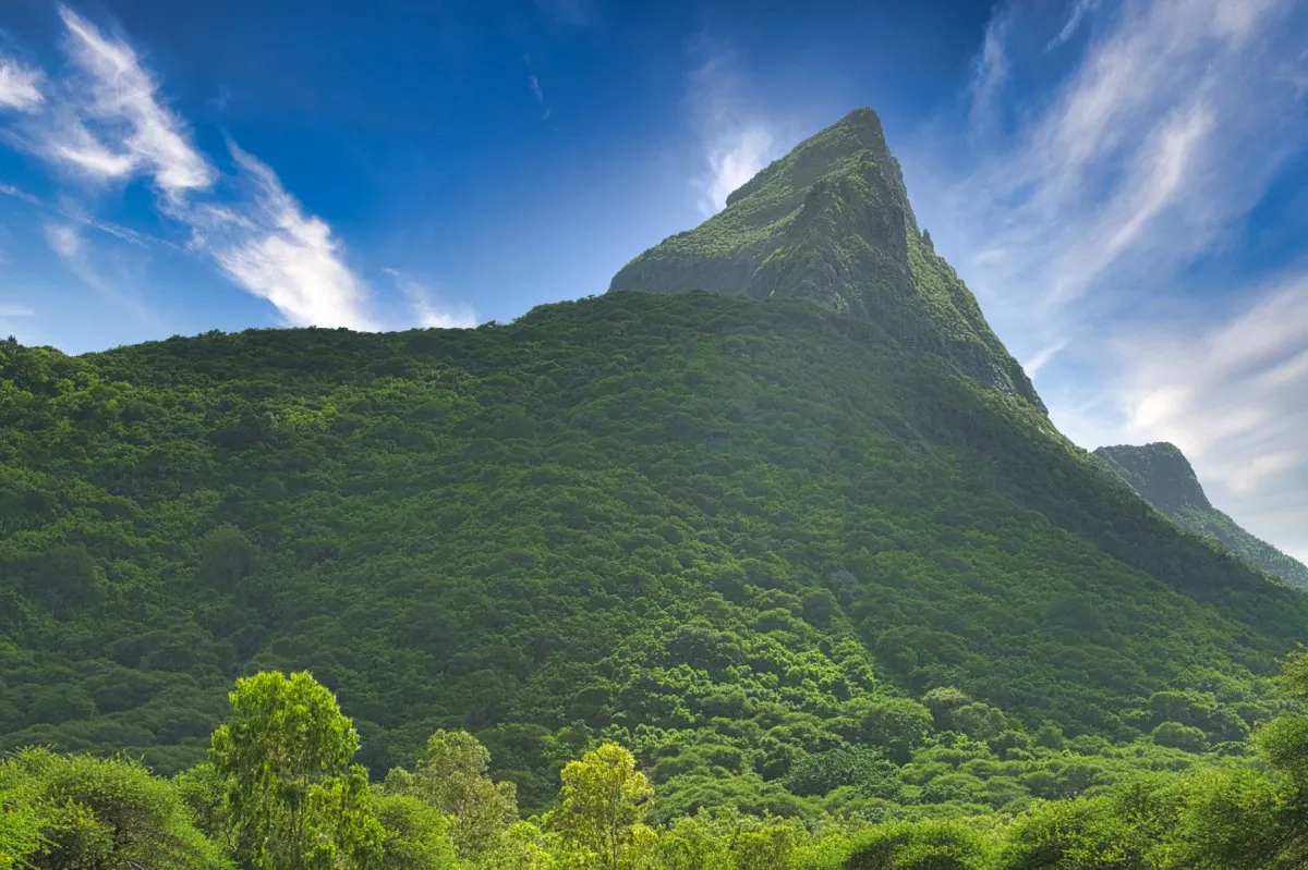Lush Rempart Mountain covered in vegetation overlooking Casela Nature Park in Mauritius after rain
