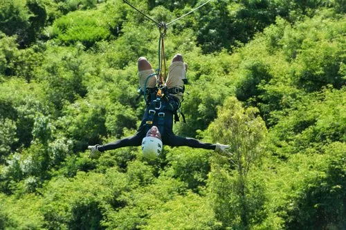 Coach sliding upside down on zip line at Casela