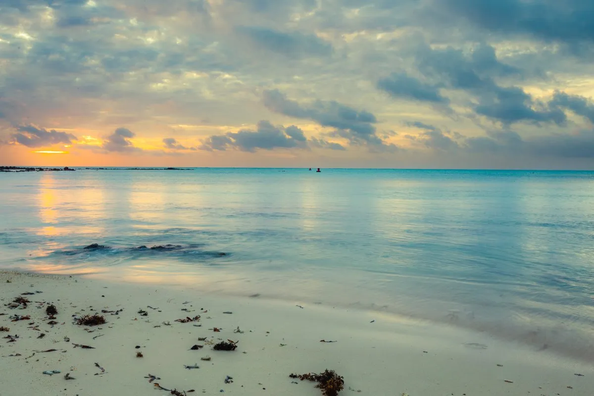 Turquoise hues over Mont Choisy beach in Mauritius during blue hour at sunset