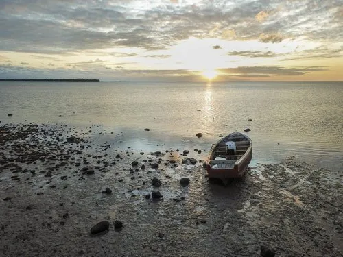 Old abandoned wooden pirogue at sea during low tide