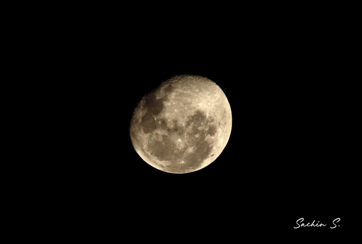 Close-up of the near full moon showing craters in the dark starless sky over Mauritius