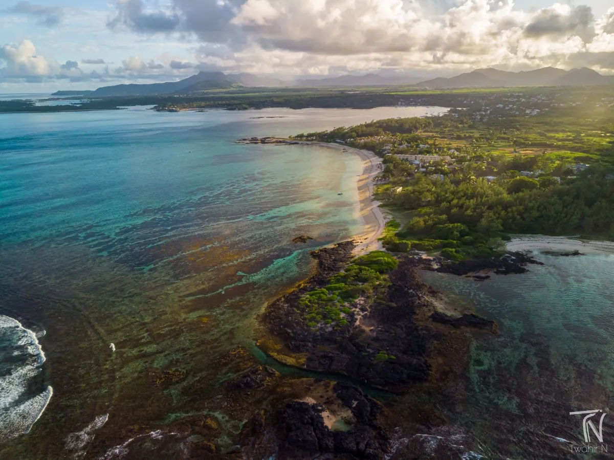 Aerial drone view of Palmar's natural pool with beach and sunset in Mauritius