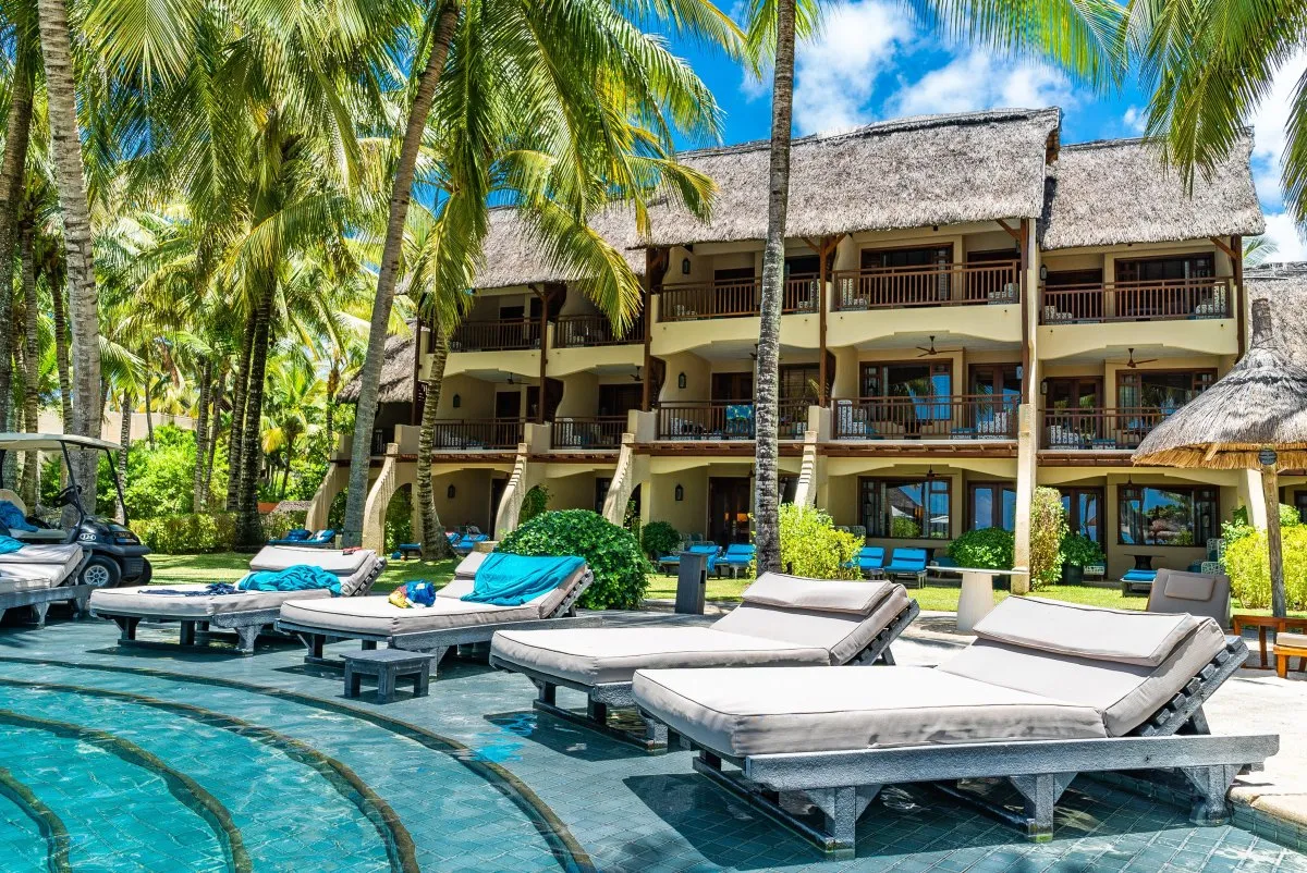 Turquoise pool with deckchairs at Constance Belle-Mare Plage hotel in Mauritius