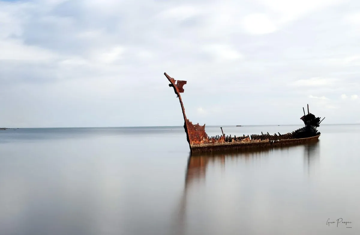 Shipwreck of SS Tayeb near the black sand Sable Noir beach in Mauritius under a cloudy sky