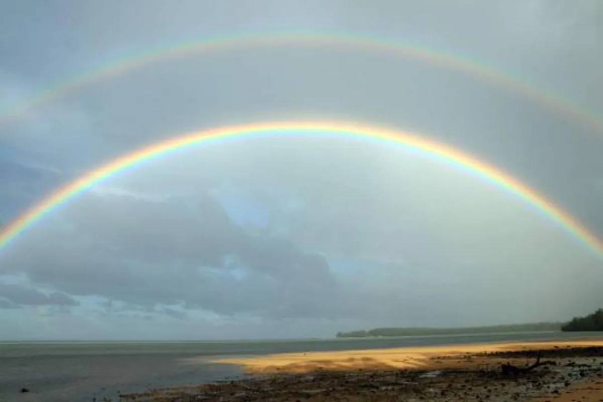Double rainbow arching over Le Morne lagoon in Mauritius with vibrant colors