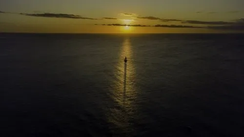 Sailboat right in the axis of the sunset