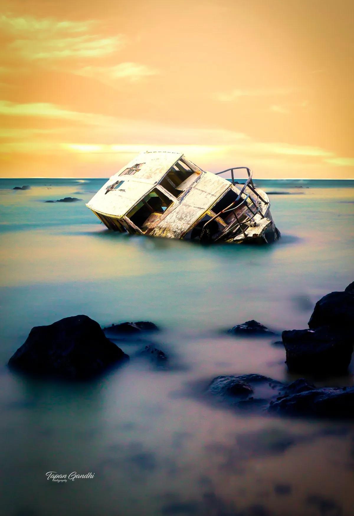 Wrecked wooden boat in the lagoon at Grand Gaube, Mauritius, surrounded by calm sea and marine life