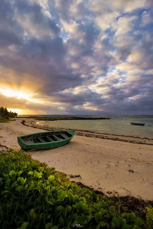 Old green boat on Belle Mare beach in Mauritius