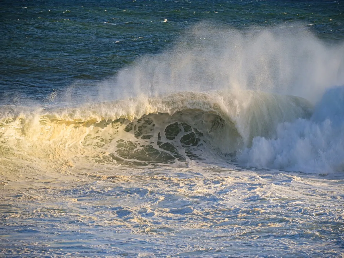 Breaking wave in the rough sea at Gris Gris on the south coast, with foaming water and sea spray.