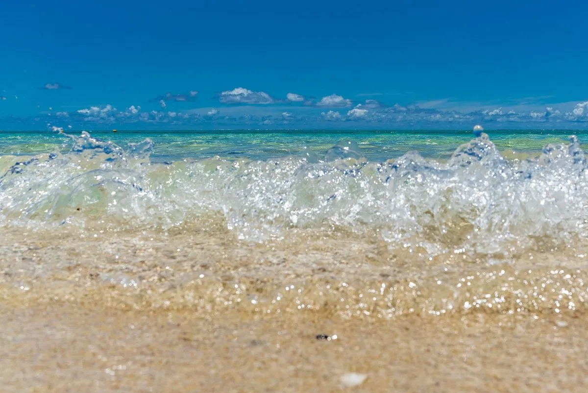 Close-up of sparkling lagoon waves gently hitting the beach in Mauritius with calm green ocean