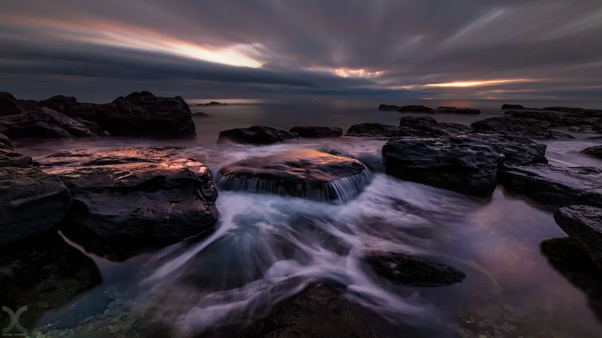 Moody rocky coast at Pointe aux Piments with moving clouds and waves in Mauritius