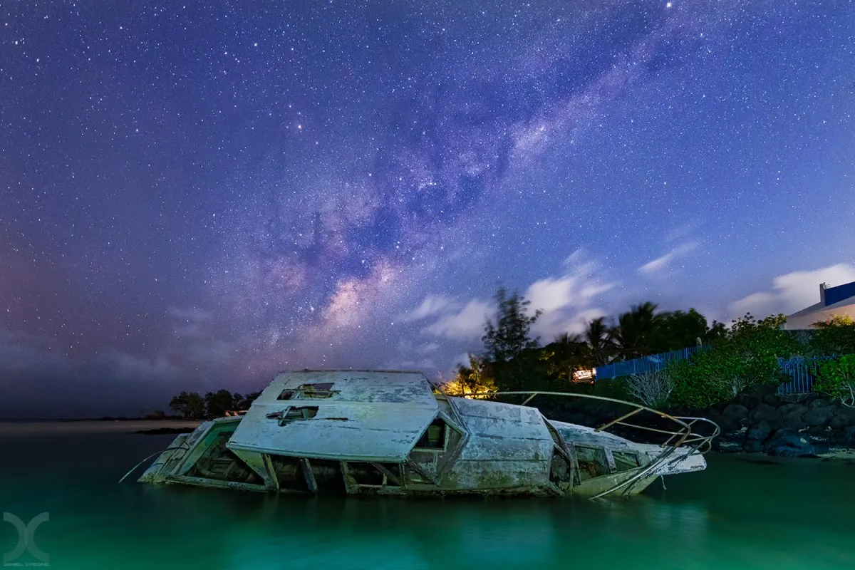 Night sky with Milky Way above Grand Gaube beach and boats in Mauritius