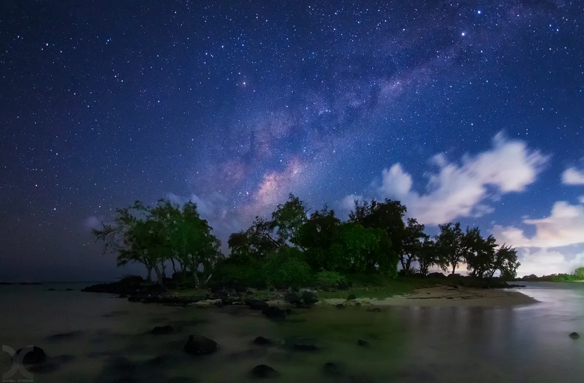 Milky Way setting behind a small islet at Grand Gaube beach under night sky in Mauritius