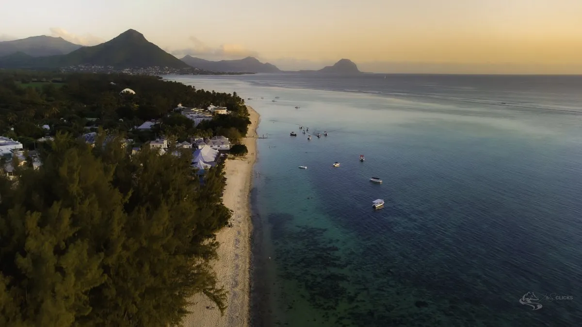 Aerial shot of Flic en Flac beach at dawn with mountains in the background in Mauritius