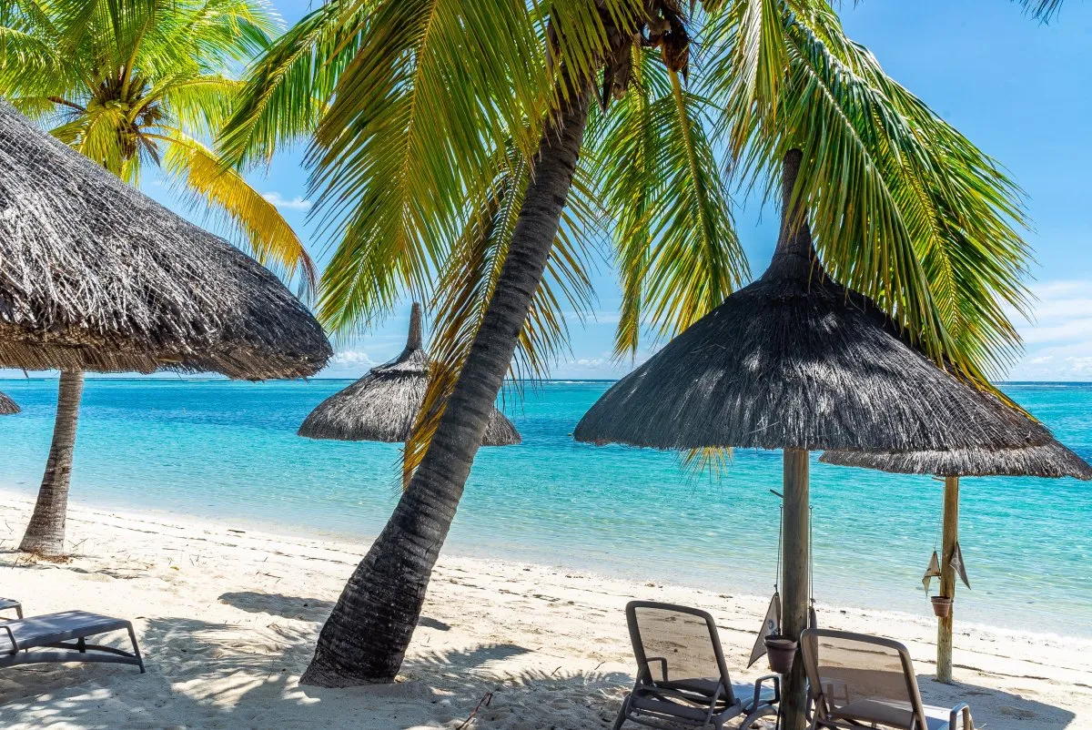 Pristine lagoon and white sandy beach with sun loungers at Le Paradis Hotel in Mauritius