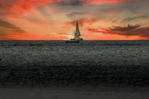 Sailboats passing the sunset at Pereybere