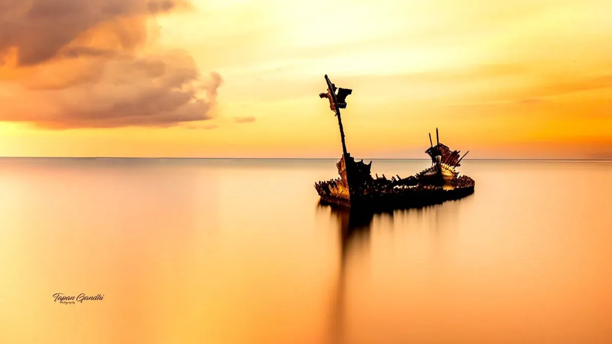 Old shipwreck on Sable Noir Beach at sunset with weathered sky in Mauritius