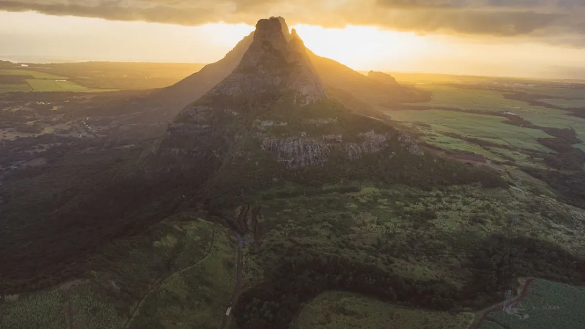 Sunset behind the three peaks of Les Trois Mamelles mountain range in Mauritius
