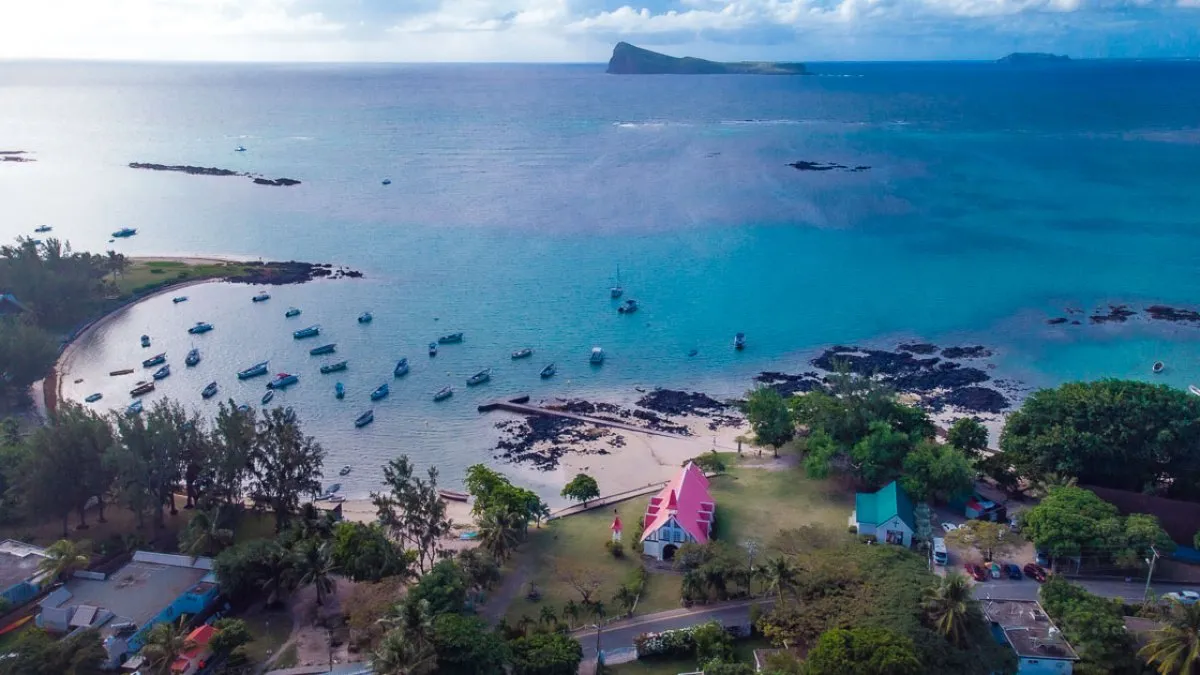 Aerial view of the red roof church with Coin de Mire island in the background in Mauritius