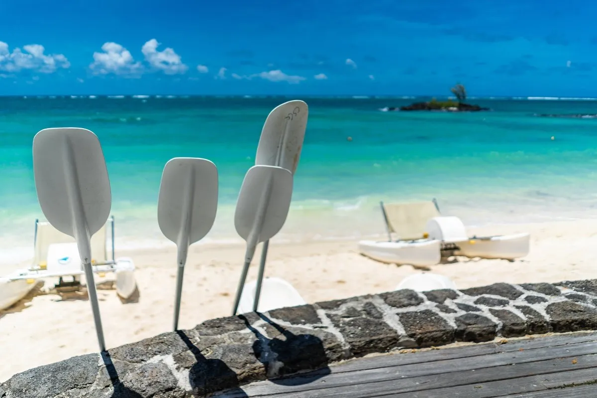 Paddle and pedalo resting on the turquoise beach at Constance Belle-Mare Plage in Mauritius