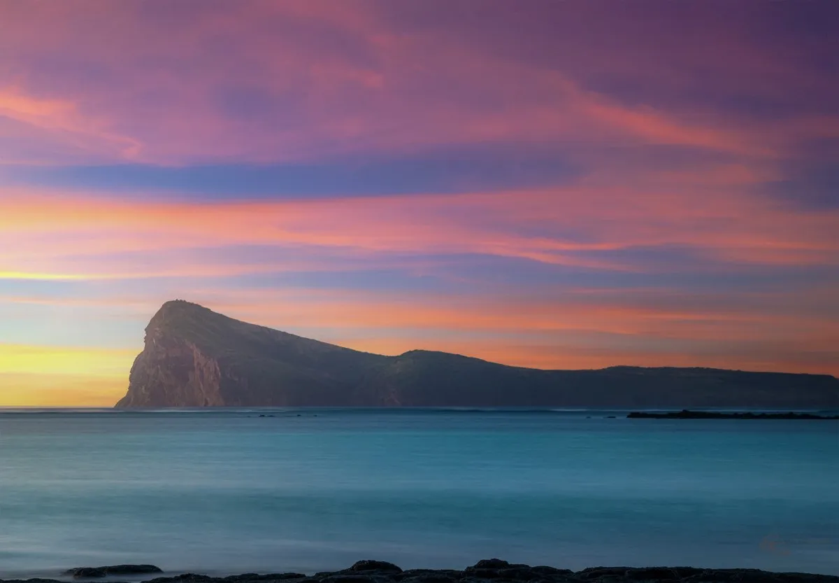 View of Coin de Mire nature reserve island with beach and mountain in Mauritius