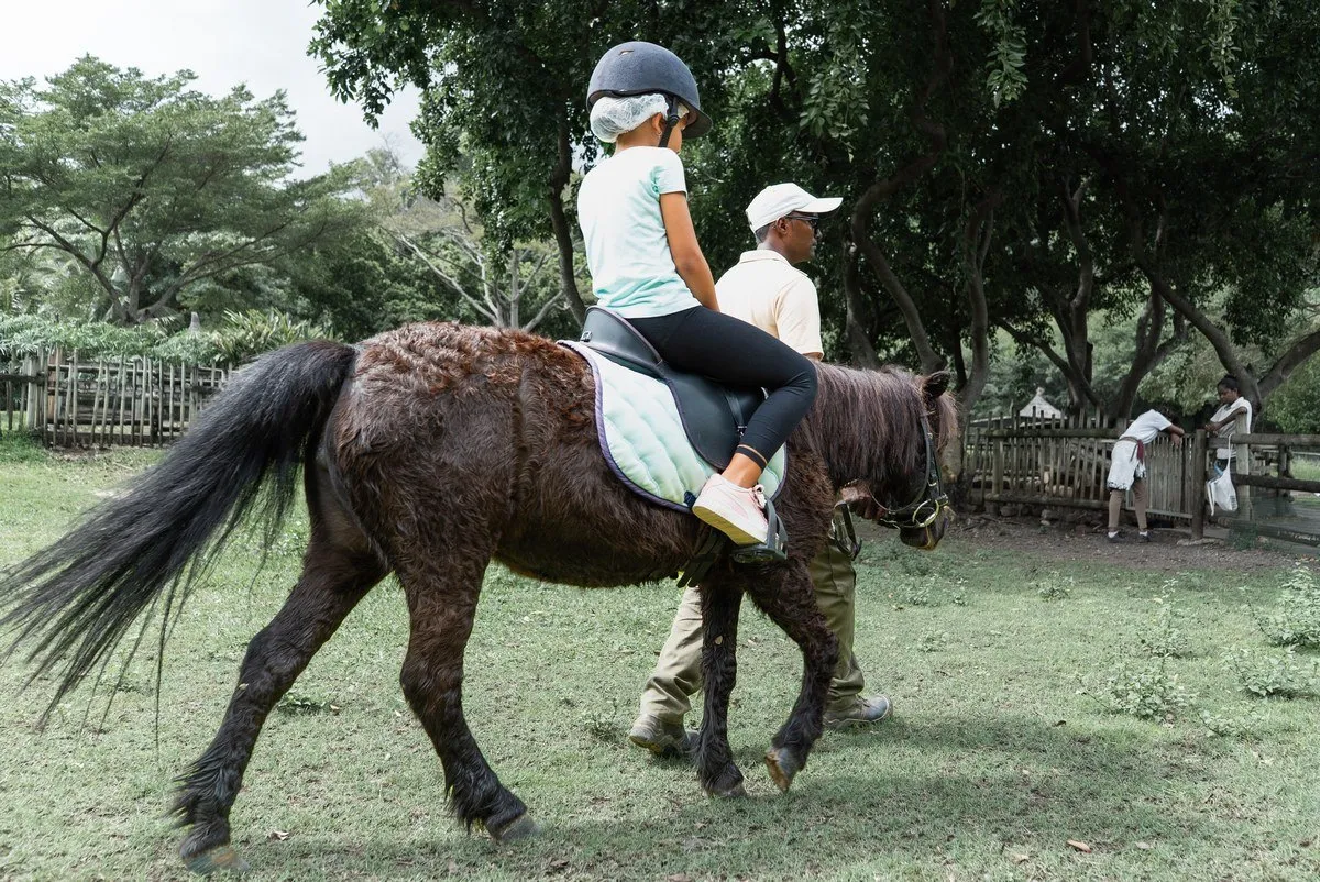 Child enjoying a pony ride at Casela Nature Parks in Mauritius under expert supervision