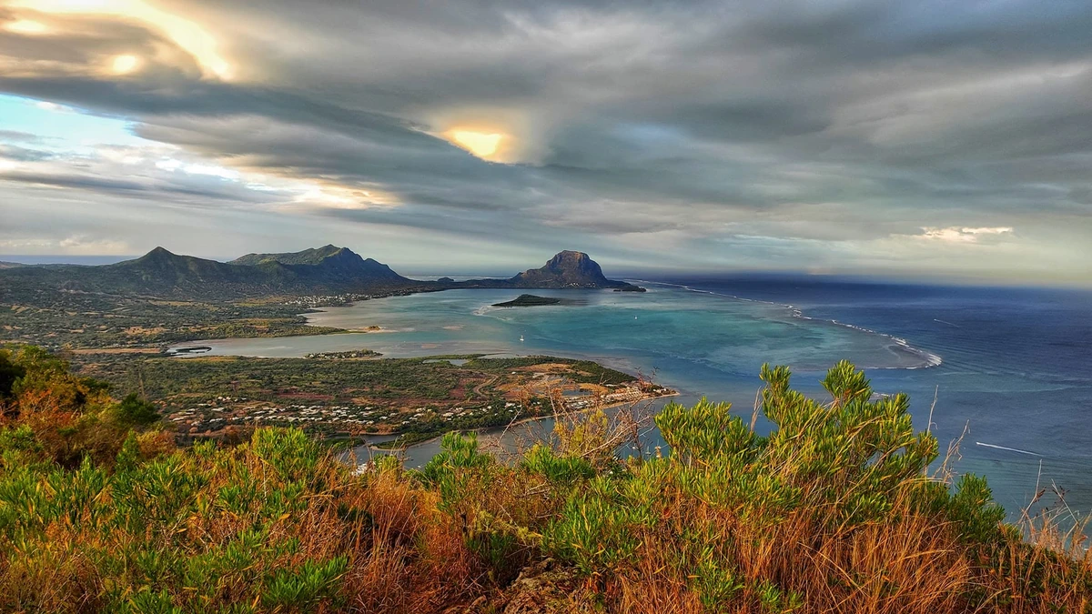 View of Le Morne Brabant and the turquoise lagoon from La Tourelle Mountain in Tamarin, with the west coast of Mauritius below.