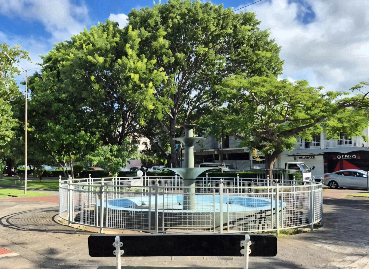 Fountain at Plaine Verte Public Garden in Port Louis, Mauritius, surrounded by mature trees and the urban neighbourhood.