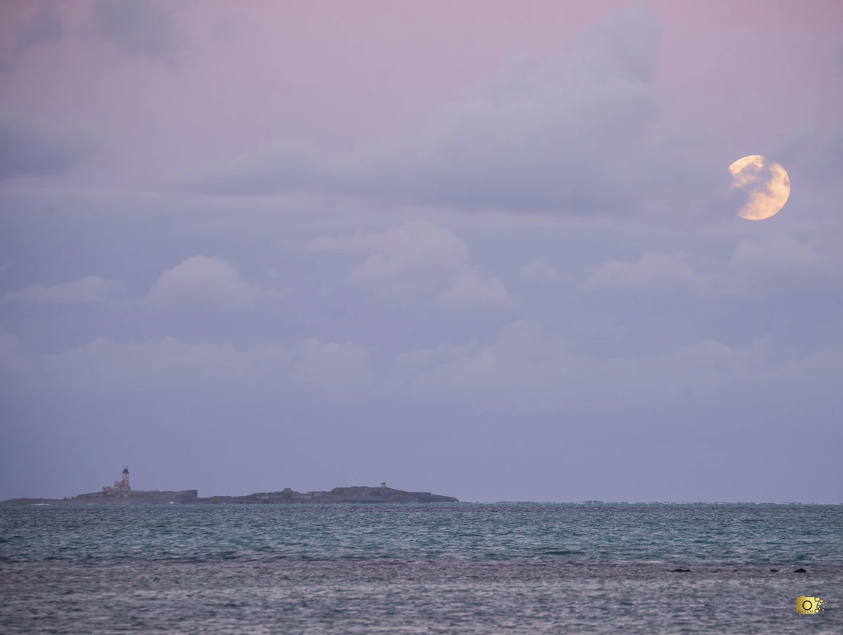 Golden harvest moon rising over Île au Phare in the bay of Mahébourg, Mauritius