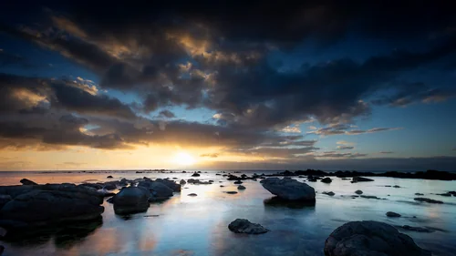 Rocky Shoreline Beneath Dramatic Sunset Clouds at Flic en Flac