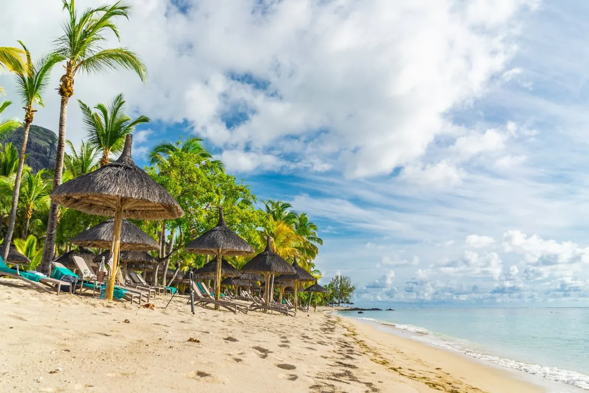 Steps in the sand at Golden Beach lagoon next to lush garden at Le Paradis Resort in Mauritius