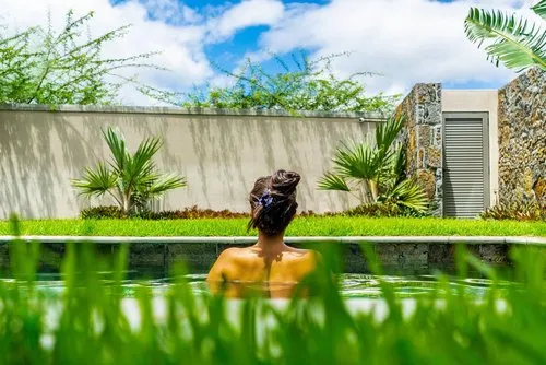 Young woman back view in pool at Mauritius villa