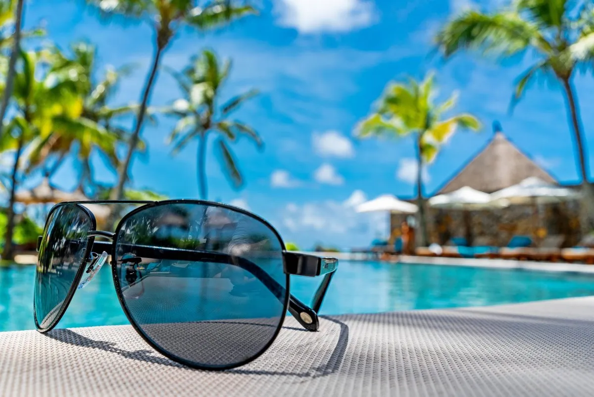 Sunglasses placed near a 5-star hotel pool at Constance Belle-Mare Plage in Mauritius