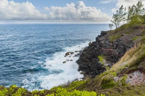 Blue cliffs edge landscape with waves crashing on rocks