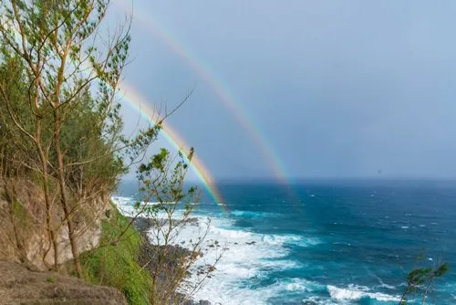 Picturesque view of two rainbows behind the cliffs