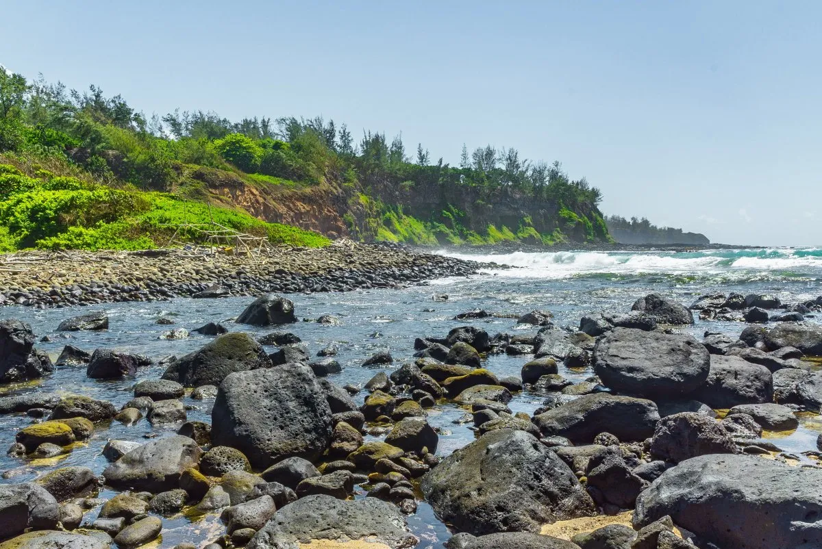 Rocky river flowing into the ocean with cliffs and green vegetation in southern Mauritius