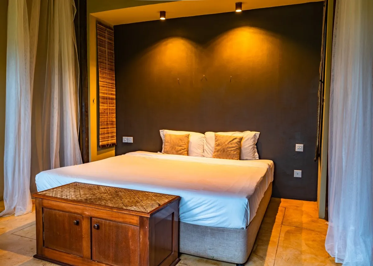 Rustic bedroom with twin bed and soft lighting at L'Exil Lodges in Mauritius