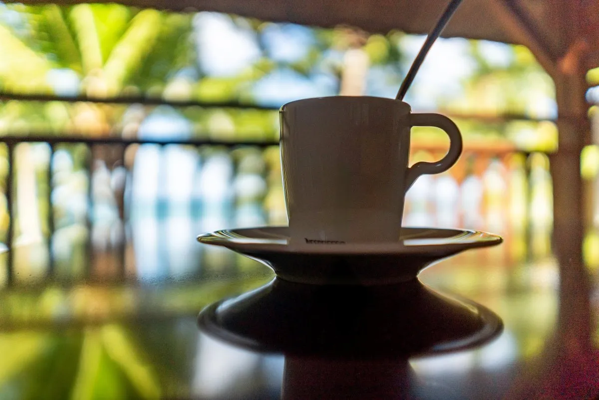 Coffee cup reflection on table at hotel terrace with sea view in Mauritius