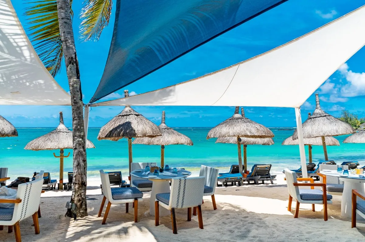 Beachfront restaurant with tables and shade sails at Constance Belle Mare in Mauritius