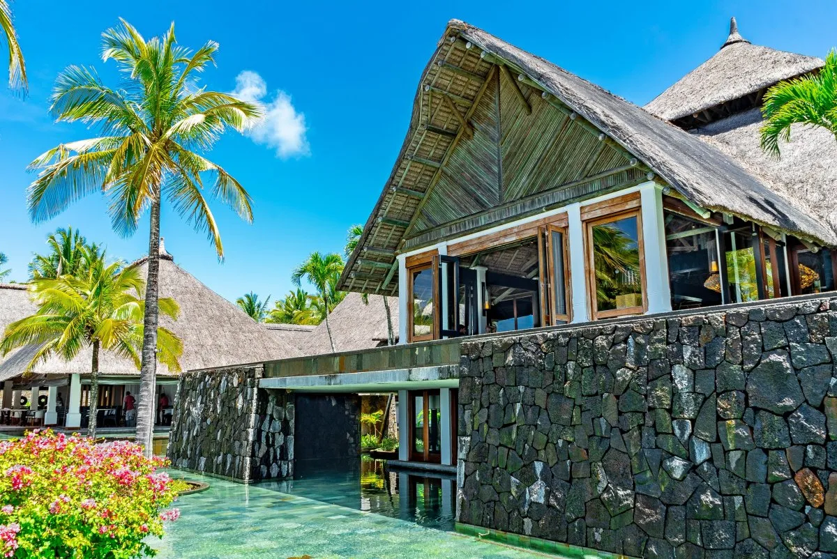 Front view of a luxury resort in Mauritius with a shallow pool and volcanic rock walls
