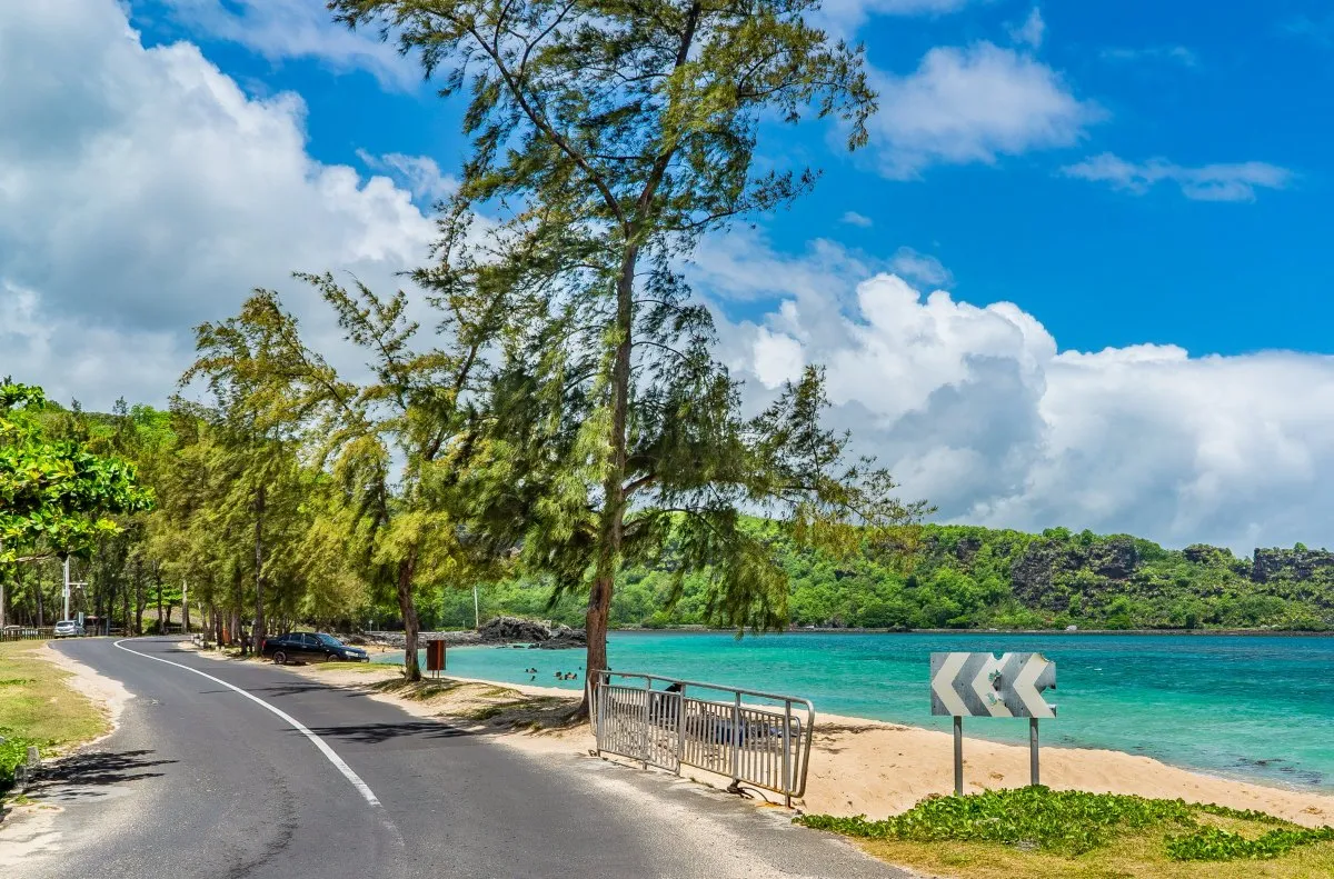 Scenic La Prairie coastal road with greenery, mountains, and turquoise lagoon in Mauritius