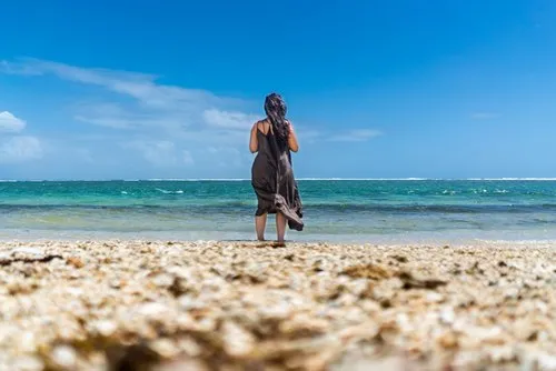 Woman standing in water and contemplating the sea
