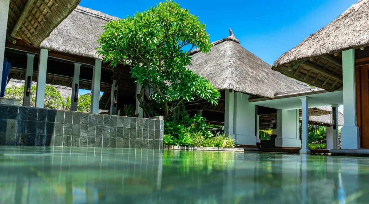Shallow decorative pool with thatch roof at Constance Belle-Mare Plage hotel in Mauritius