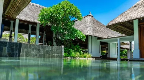 Shallow decorative pool at Constance Mauritius with Thatch Roof