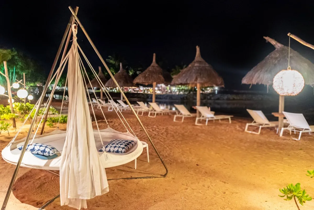Floating teepee tent bed on Heritage C Beach Club shore in Mauritius at night