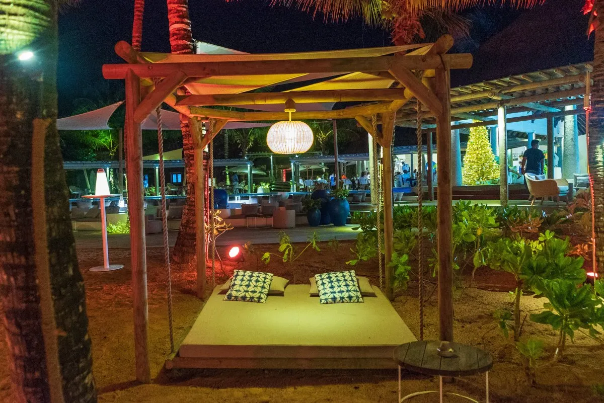 Hanging wooden beach bed at night in a cozy beach garden setting in Mauritius