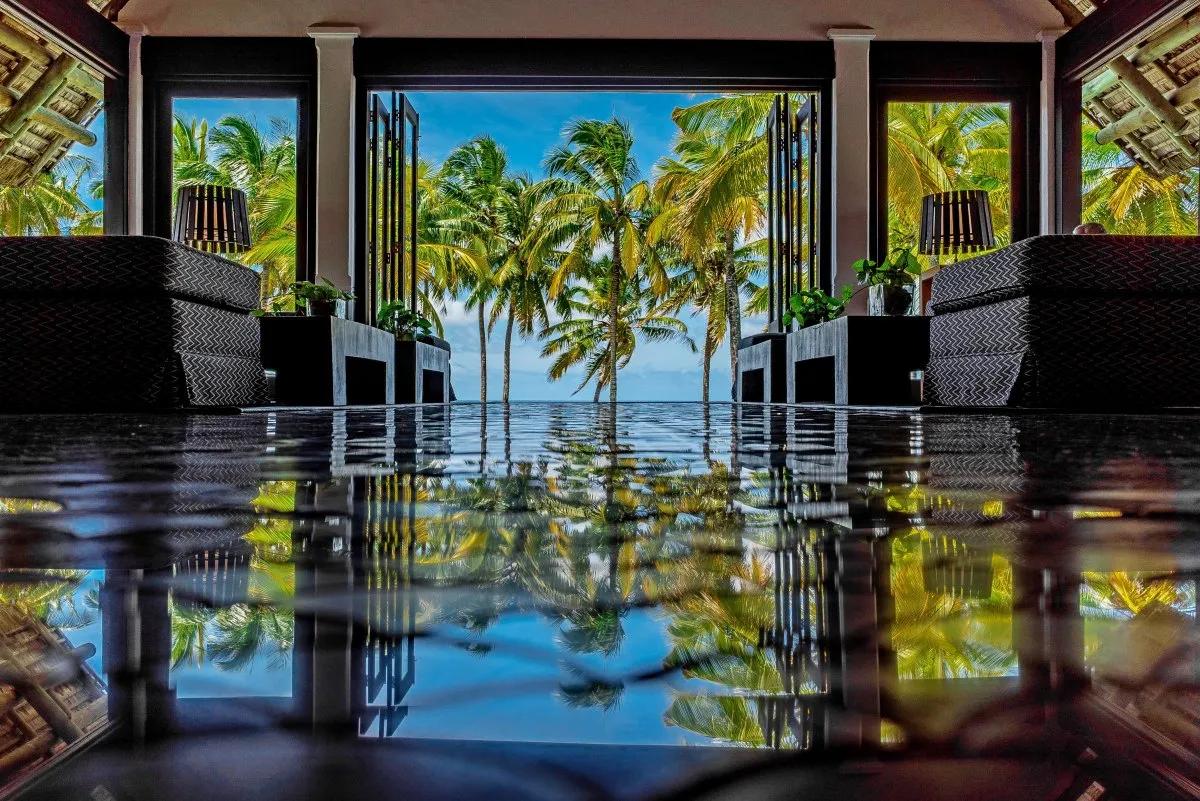 Reflection of palm trees on the floor at Constance Belle-Mare Plage hotel lobby in Mauritius
