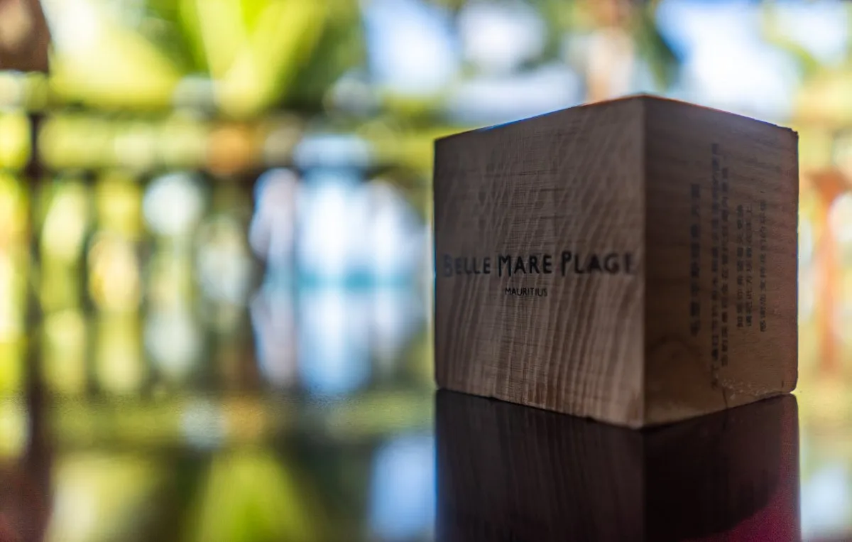 Wooden cube reflecting on a table under a terrace at Constance Belle-Mare Plage Hotel in Mauritius
