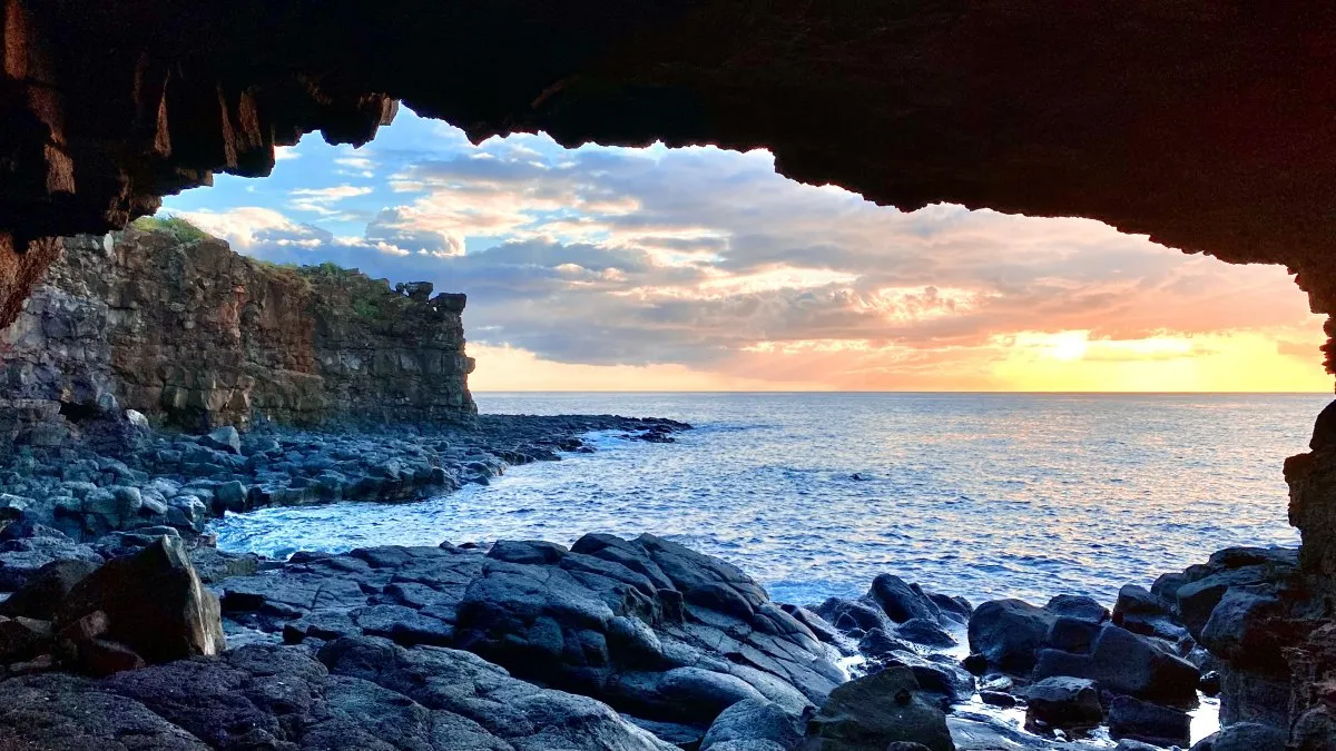 Sunset view over the rocky coast of Albion in Mauritius with the sea and sky glowing orange.